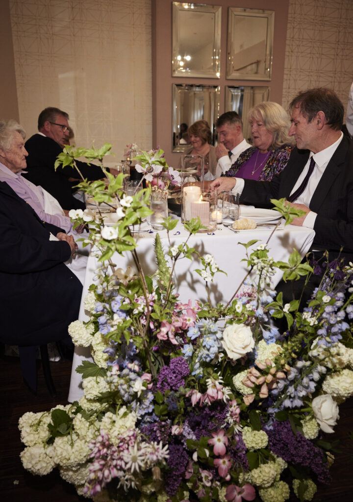 People eating dinner with flowers on the ground