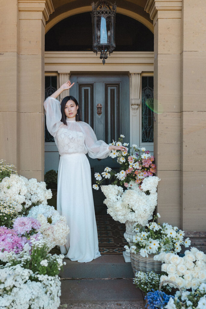 The image features a woman standing outdoors in a white wedding dress